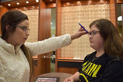 学生们在罗恩州立视力诊所练习安装眼镜.